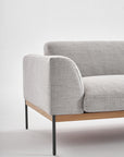 The Wooden Stories Department Sofa 93" | Fabric is a modern light gray sofa with Danish-style lines, black metal legs, and a solid wood plinth. Shown against a white background, only one armrest and part of the seat are visible.