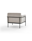 The Scribe Lounge Chair by Wooden Stories features light beige fabric upholstery and a Bauhaus-inspired metal frame, shown from the back against a white background.