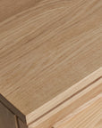 A close-up of the Yorke Sideboard by Wooden Stories showcases its smooth solid oak surface and natural wood grain, reflecting elegant Scandinavian-inspired design.