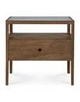 The Spindle Nightstand - Teak by Ethnicraft is crafted from FSC-certified teak and features four legs, a glass top, an open shelf, and a single drawer with a round hole handle.