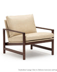 The Troubadour Lounge Chair by Wooden Stories features light beige leather cushions and a solid oak frame, showcasing a minimalist design with angled armrests and a sturdy base inspired by Danish classics.