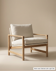 The Troubadour Lounge Chair | Fabric by Wooden Stories features a solid oak frame and beige cushions, showcased against a plain, light-colored background. Part of the Danish Collection, its minimalistic and contemporary design offers a modern lounge seating solution.