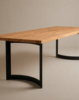 The SOBU Tommaso Dining Table features a modern solid wood top with a natural finish and curved black metal legs, displayed against a plain beige background.