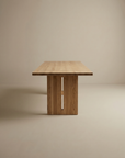 The Tommaso Dining Table by SOBU features a minimalist solid wood design with a rectangular top and sturdy wood legs, shown against a plain beige background.