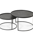 The Ethnicraft Tray Coffee Table - Set of 2 features two round, black nesting tables with slim metal frames and flat tops. The smaller table tucks under the larger one for a stylish, space-saving design.