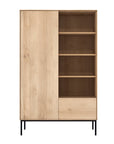 The Ethnicraft Whitebird Storage Cupboard – Oak features a light oak finish, four right open shelves, a left door, lower drawer, and slim black metal legs—showcasing the Whitebird Collection’s timeless style.