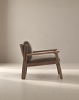 The Wren Lounge Chair | Fabric by Wooden Stories is a modern wooden armchair inspired by Danish design, featuring a light brown cushioned seat and backrest crafted from solid walnut, photographed from the side against a neutral beige background.