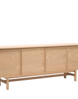 The Yorke Sideboard by Wooden Stories features four doors, clean minimalist lines, and raised legs—an elegant solid oak piece inspired by classic Scandinavian design.