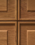 Close-up of four solid oak doors on the Wooden Stories Yorke Sideboard, each featuring a raised rectangular panel and natural brown wood grain. The intersecting panels form a cross, exemplifying classic Scandinavian design.