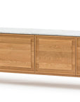 The Yorke Sideboard with Stone Top by Wooden Stories features four paneled doors, a modern design, white stone top, and slender legs with elegant Danish lines.