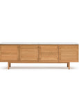 The Yorke Sideboard with Stone Top by Wooden Stories features four paneled doors, a refined paneled design, a white marble top, and short wooden legs, displayed against a plain white background.