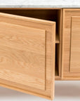 A close-up of the Wooden Stories Yorke Sideboard with Stone Top shows its light wood finish, clean Danish lines, and one door partially open to reveal the interior.