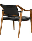The Garibaldi Chair by Noir Trading Inc. features a modern teak frame, black leather backrest and seat cushion, angled legs, and curved armrests for a sleek, contemporary look when viewed from behind at an angle.