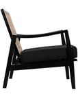 Side view of the Lichtenstein Chair by Noir Trading Inc., showcasing its solid Sungkai wood black frame, woven cane backrest, and thick black seat cushion, all set against a white background.
