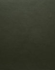 Close-up of dark green, textured leather with a fine pebbled grain, featured in Wooden Stories' Fabric + Leather Swatches collection, shown under even lighting to highlight its flawless, custom made-to-order finish.