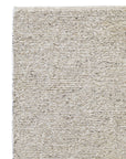 Close-up of the Andorra Rug - Terrazzo by Armadillo&Co in beige and light gray, highlighting its subtle horizontal pattern, Fair Trade wool, notable thickness, and tight weave.