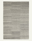 The Aspen Rug - Blizzard by Armadillo&Co is a hand-knotted rectangular gray rug with a subtle, textured pattern and varying gray tones, shown on a plain light background.