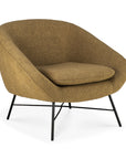 The Ethnicraft Barrow Lounge Chair - Ginger is a modern, upholstered armchair with ginger fabric, a rounded backrest, angled black metal legs, and a thick seat cushion for subtle vintage flair.