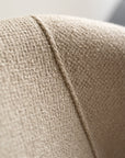Close-up of the off white textured fabric with a diagonal seam, highlighting the detailed craftsmanship and subtle vintage feel of the Ethnicraft Barrow Lounge Chair.