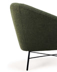 Close-up view of the Ethnicraft Barrow Lounge Chair – Pine, showcasing textured pine green upholstery and slim black metal legs, bringing a refined vintage touch against a white background.