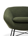 A close-up of the Ethnicraft Barrow Lounge Chair - Pine shows its green textured fabric, rounded edges, and black metal legs, bringing vintage flair against a crisp white background.