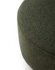 Close-up of the Barrow Pouf - Pine / Small by Ethnicraft, showing its textured Italian fabric in dark green, with only part of the top and side visible against a white background.