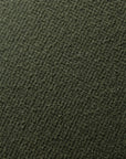 Close-up of the Barrow Pouf - Pine / Small by Ethnicraft, showcasing its textured dark green fabric with a subtle diagonal pattern and soft, woven look inspired by premium Italian textiles.