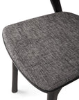 Close-up of the Ethnicraft Bok Dining Chair in Black Oak with Grey Fabric, showcasing its textured seat, backrest, and dark solid oak legs.