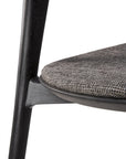 Close-up of the Ethnicraft Bok Dining Chair - Black Oak with Grey Fabric, highlighting the textured grey upholstered seat and sturdy black oak leg.
