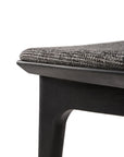 Close-up of the Ethnicraft Bok Dining Chair - Black Oak with Grey Fabric, showcasing its black oak frame and textured dark gray upholstered seat against a white background.