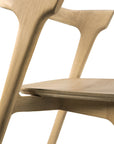 Close-up of the Ethnicraft Bok Dining Chair - Oak, highlighting its smooth solid oak construction, clean angular lines, and minimalist design against a white background.