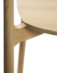 Close-up of the Ethnicraft Bok Dining Chair - Oak, showing its smooth, rounded seat, seamless joinery, minimalist silhouette, and natural oak grain.