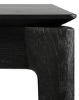 Close-up of the Bok Extendable Dining Table - Black by Ethnicraft, crafted from solid European oak, highlighting its textured grain and modern, angular tabletop and leg design.