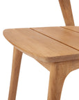 Close-up of the Ethnicraft Bok Outdoor Dining Chair in FSC certified natural teak, highlighting the smooth finish, visible wood grain, and gently rounded edges on the seat and legs.