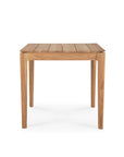 The Bok Outdoor Dining Table by Ethnicraft features a square, slatted top and four straight legs, crafted from natural solid teak and shown against a white background.