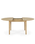 The Ethnicraft Bok Round Extendable Dining Table in oak features a light finish and classic design, shown partially extended with a center gap for the leaf, and stands on four straight legs.