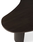 Close-up view of the Boomerang Coffee Table by Ethnicraft, featuring a varnished mahogany top and a fluted cylindrical base, shown against a white background.