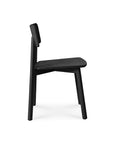 The Casale Dining Chair - Black by Ethnicraft features minimalist European oak construction with three visible legs, an angled backrest, and a flat seat. Shown in profile on white background; pairs perfectly with an Ethnicraft dining table.