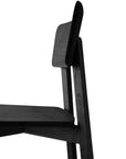 The Casale Dining Chair - Black by Ethnicraft, shown in side view against a white background, features minimalist European oak construction with a flat seat and rectangular backrest—ideal for complementing an Ethnicraft dining table.