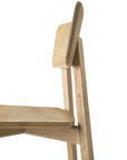 A close-up side view of the Ethnicraft Casale Dining Chair - Oak featuring a minimalist design with a flat seat, angled legs, and a rectangular backrest crafted from light European oak, set against a plain white background.