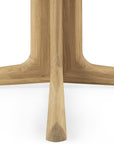 Close-up of the Corto Dining Table - Oak Square by Ethnicraft, featuring three angled European oak legs with a smooth, natural finish joined at the center, set against a white background.