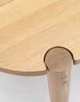 Close-up of the Cove Dining Table - Light Oak by Wooden Stories, inspired by Sydney Harbor, featuring a smooth tabletop grain and a rounded leg seamlessly fitted into a circular edge cutout—ideal for an elevated dining experience.