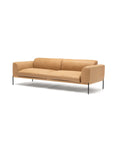 The Department Sofa 93" by Wooden Stories features modern Danish lines, tan leather upholstery, thin black metal legs, and low armrests, displayed on an upholstered platform against a plain white background.