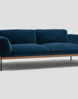 The Department Sofa 81" by Wooden Stories showcases deep blue velvet fabric, plush cushions, Danish-inspired lines, upholstered panels, a solid wood plinth, and slim black metal legs, set against a plain light gray background.