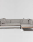 The Wooden Stories Department Modular Sofa | Fabric • M6 Right features light gray upholstery, thin black metal legs, and an FSC-certified oak base with three matching cushions, shown against a plain white background.