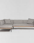 The Department Modular Sofa | Fabric • M6 by Wooden Stories is a modern light gray L-shaped sectional with two matching cushions, black metal legs, and an FSC-certified oak base inspired by Danish design, shown on a plain white background.
