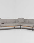 The Department Modular Sofa | Fabric • M6 by Wooden Stories is an L-shaped sectional with light gray upholstery, slim black metal legs, and FSC-certified oak trim. Two matching gray cushions are on the sofa, set against a plain white background.