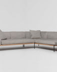 The Department Modular Sofa | Fabric • M6 by Wooden Stories is an L-shaped sectional with light gray upholstery, slim black metal legs, and FSC-certified oak trim. Two matching gray cushions are on the sofa, set against a plain white background.