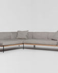 The Department Modular Sofa | Fabric • M6 by Wooden Stories features a modern L-shaped design in gray fabric with slim black metal legs and two matching cushions, inspired by Danish collections, shown on a white background.