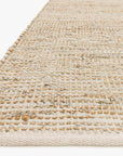 A close-up of the Loloi Edge Rug - Ivory shows its hand-woven, textured pattern in beige, tan, and light gray on a white background for a natural look.